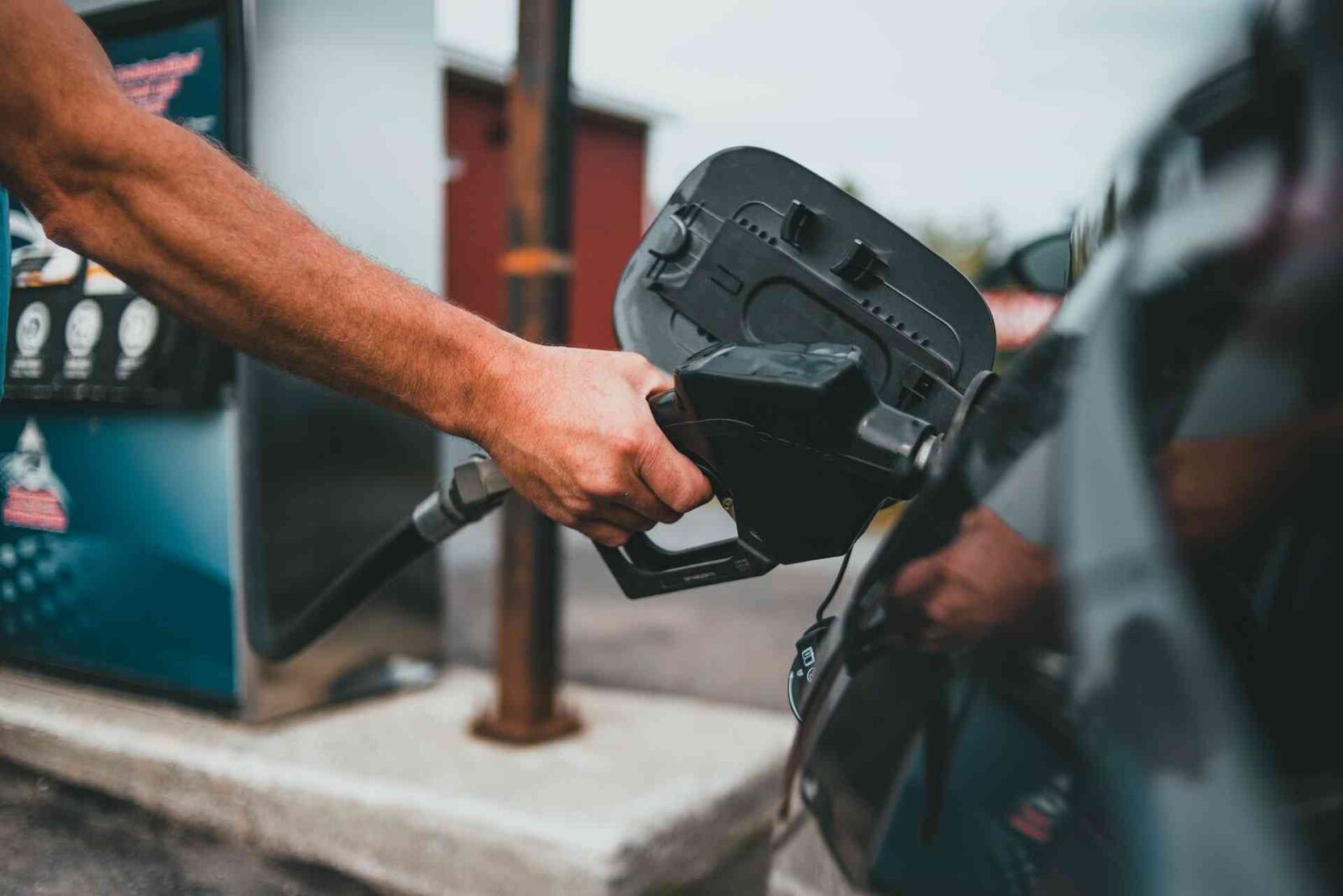 man holding a gas pump to fill his car with fuel