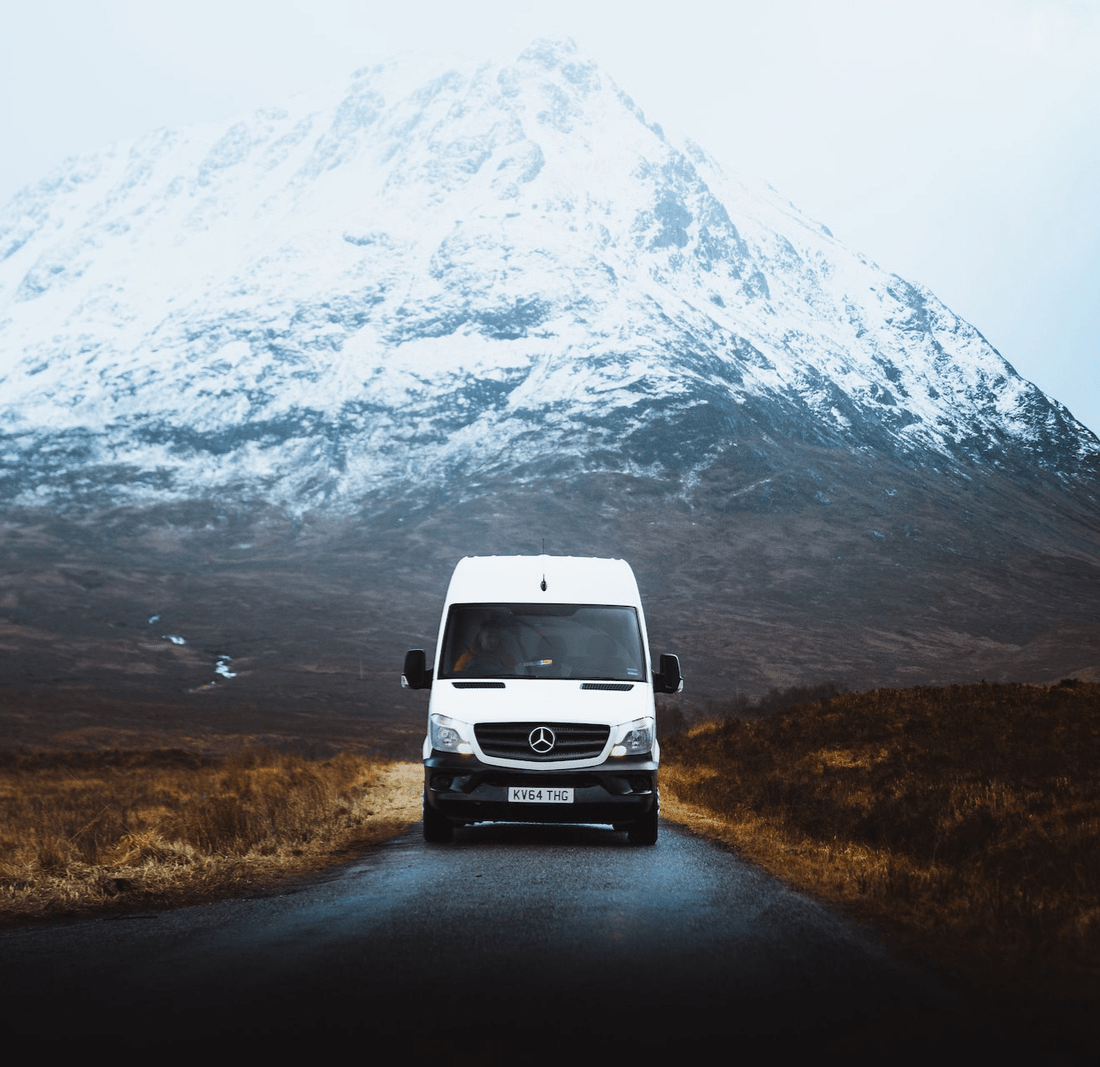 Mercedes Van in the middle of a snowy hill, driving down a lane.