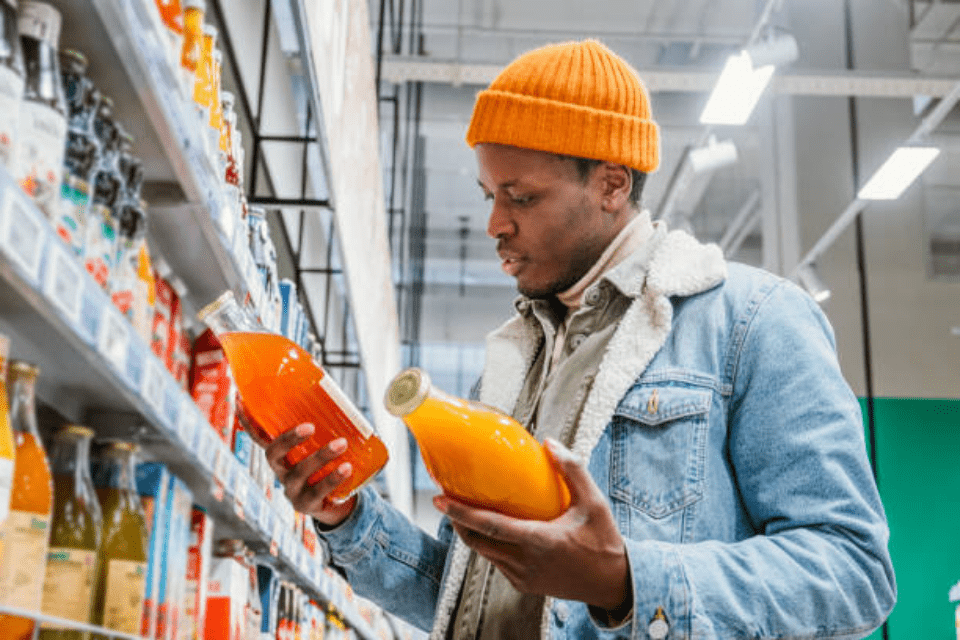Person Looking at Multiple Bottles from a Shelf