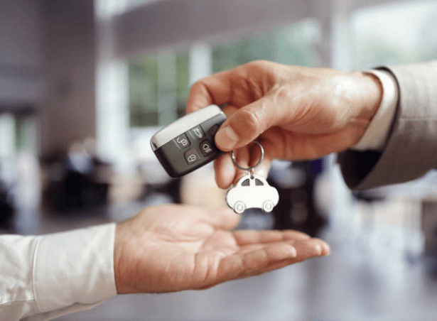 Person Handing Car Keys to Another Person